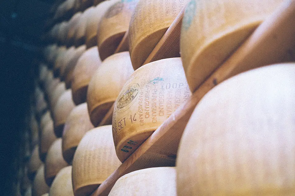 A close up of a a stack of shelves with Parmesan Cheese on them